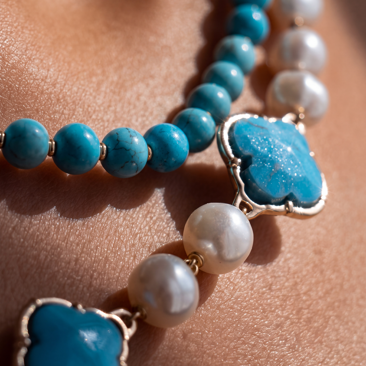 Dettaglio di bijoux con perle bianche e pietre color turchese