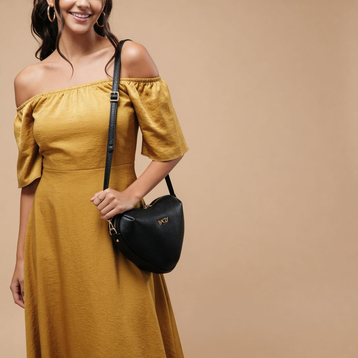 Borsa a tracolla Bagly nera indossata con un abito giallo