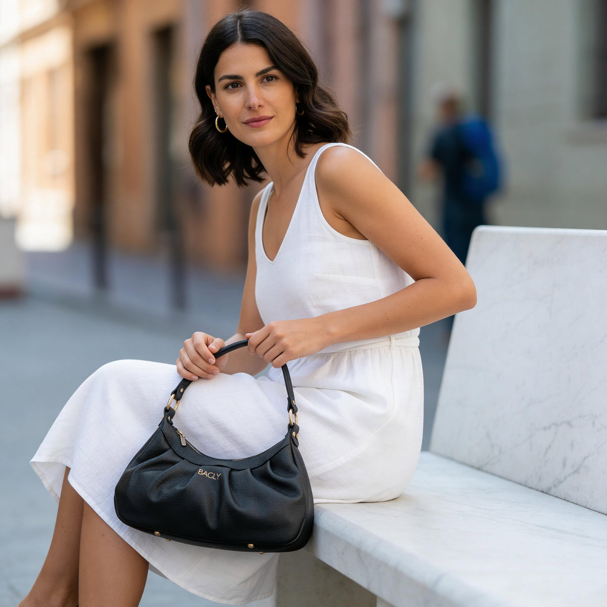 Borsa nera Bagly indossata con un abito bianco